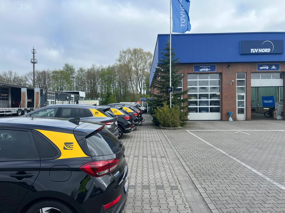 Reihe gebrandeter Fahrschulwagen der Fahrschule Rüther, nebeneinander aufgereiht